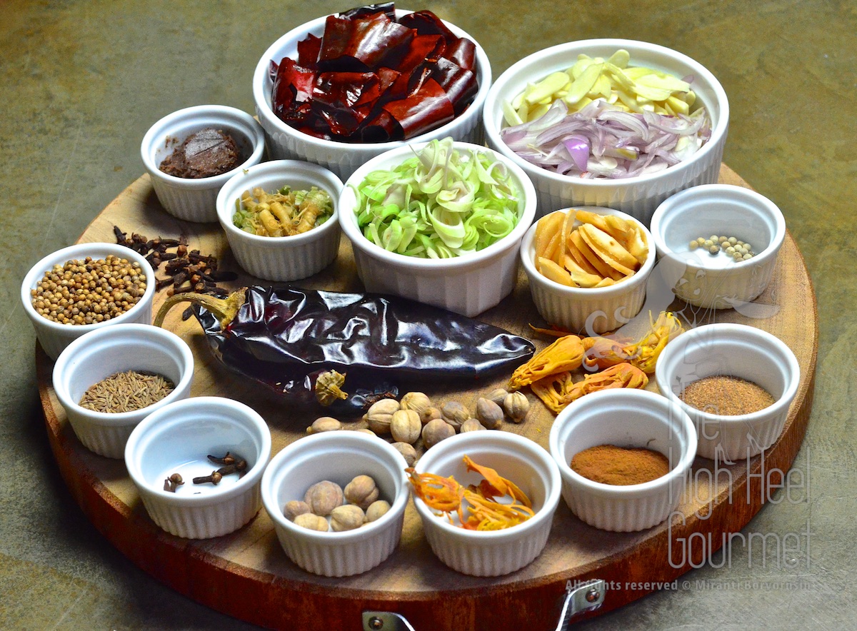 These are all the ingredients I use in the Massaman curry paste. I divided the ingredients into three sections. The top part is the "herbs", or the basic Thai curry paste ingredients. The middle part is just showing you some of the ingredients to clarify their appearance before the abuse. The bottom part is the "spices" that are only contained in Massaman curry. Top (clockwise): Red dried California chili, soaked, de-seeded and cut; Garlic and Shallots, sliced; White Peppercorns; Galangal, sliced; Lemongrass, sliced; Cilantro (coriander) root, cleaned and cut; Shrimp paste, roasted. Middle (from left to right): Whole Cloves, Whole California Chili before being cut up, Whole White Cardamom, Whole Mace. Bottom (form right to left): Ground Nutmeg, Ground Cinnamon, Whole Mace, Whole White Cardamom, Whole Cloves, Cumin seeds, Coriander seeds 